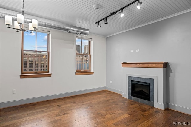 149 Swan St Unit 310, Buffalo, NY 14203 - unfurnished living room featuring rail lighting, a chandelier, wood finished floors, a fireplace, and ornamental molding