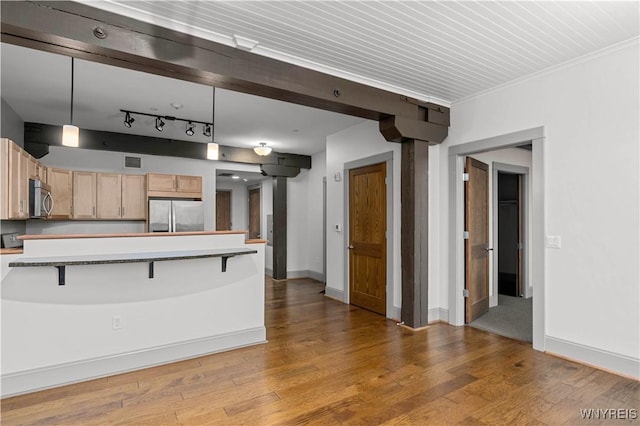 149 Swan St Unit 310, Buffalo, NY 14203 - kitchen featuring stainless steel appliances, a kitchen bar, light wood-type flooring, light brown cabinetry, and decorative light fixtures