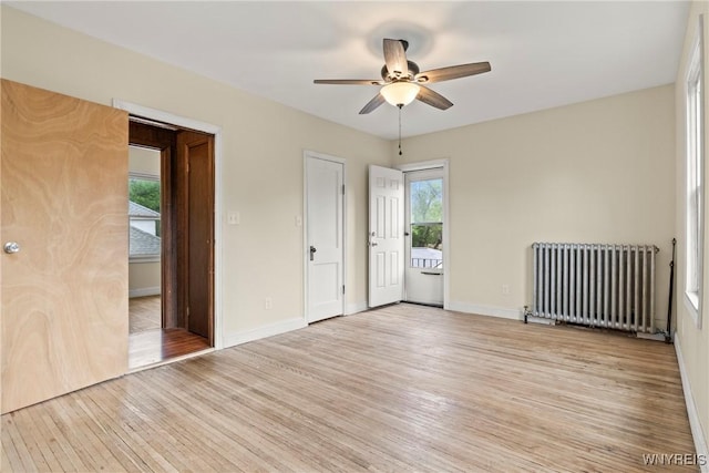 540 Longmeadow Rd, Amherst, NY 14226 - spare room featuring radiator heating unit, light wood-style floors, a ceiling fan, and plenty of natural light