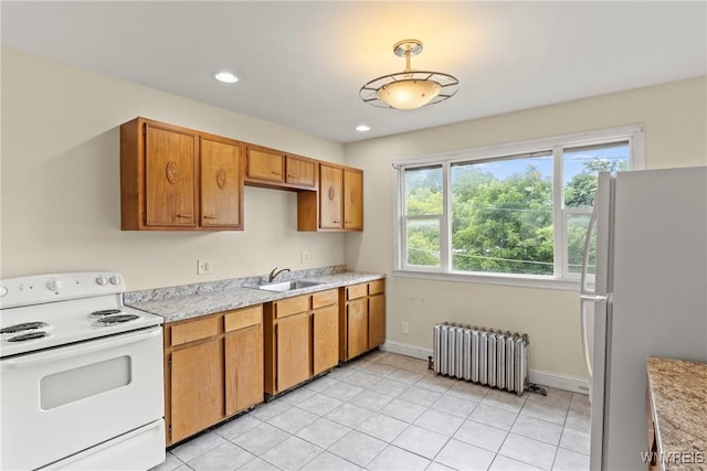 540 Longmeadow Rd, Amherst, NY 14226 - kitchen with white appliances, radiator, light countertops, brown cabinets, and light tile patterned floors