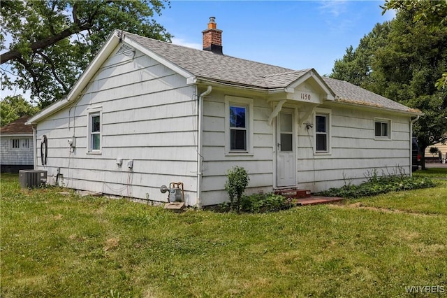 1142 Harlem Rd, Cheektowaga, NY 14227 - view of front of house featuring entry steps, a front lawn, a chimney, and a shingled roof
