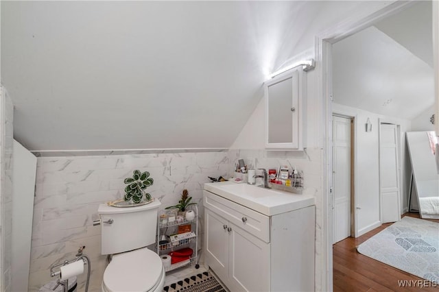 1142 Harlem Rd, Cheektowaga, NY 14227 - bathroom featuring vanity, tile walls, vaulted ceiling, and wood finished floors