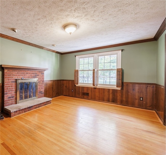 1225 Majestic Way, Webster, NY 14580 - unfurnished living room with a wainscoted wall, wood finished floors, wood walls, a textured ceiling, and crown molding