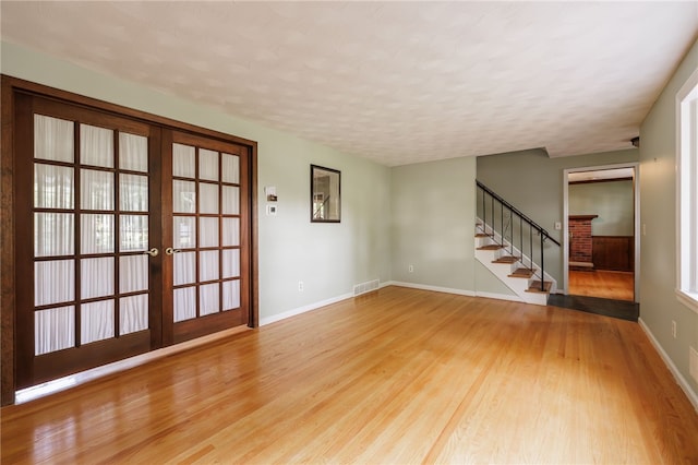 1225 Majestic Way, Webster, NY 14580 - unfurnished room with light wood-type flooring, stairs, french doors, and a textured ceiling