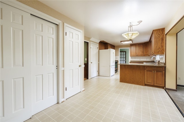 1225 Majestic Way, Webster, NY 14580 - kitchen featuring freestanding refrigerator, brown cabinets, a peninsula, decorative light fixtures, and light countertops