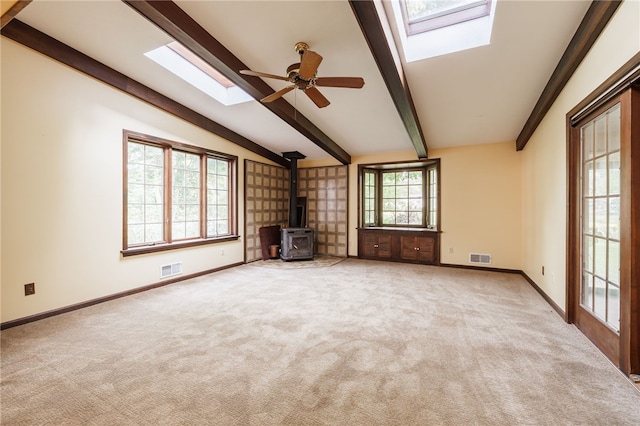 1225 Majestic Way, Webster, NY 14580 - unfurnished living room featuring a skylight, a wood stove, carpet, and a ceiling fan