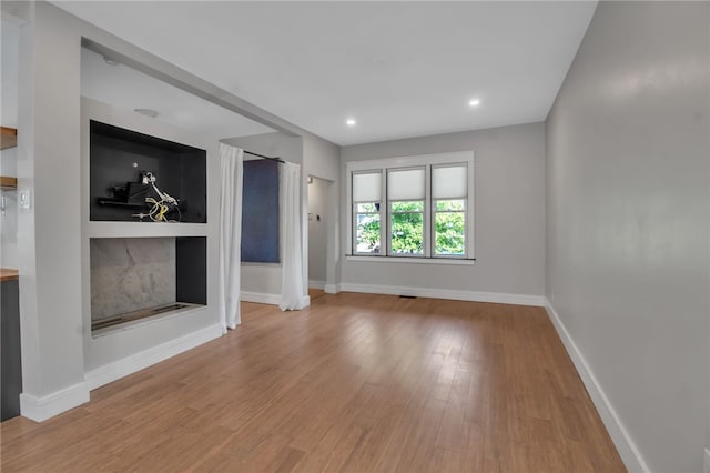 373 Rhode Island St, Buffalo, NY 14213 - unfurnished living room with built in features, wood finished floors, and recessed lighting