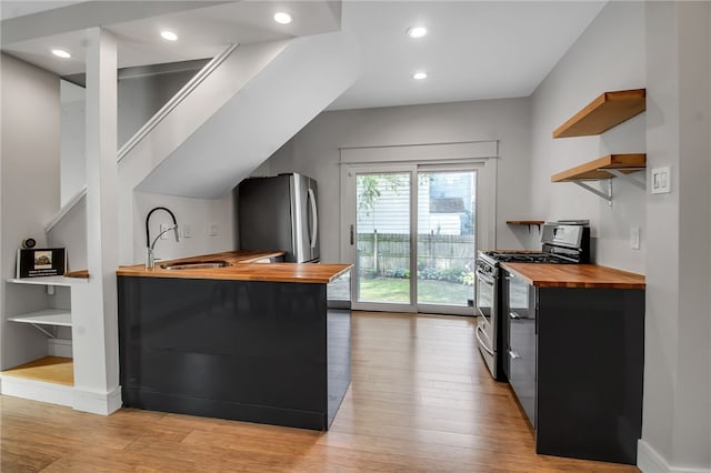 373 Rhode Island St, Buffalo, NY 14213 - kitchen with butcher block counters, open shelves, stainless steel appliances, dark cabinetry, and light wood-style floors
