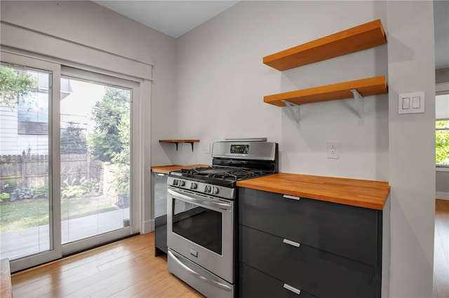 373 Rhode Island St, Buffalo, NY 14213 - kitchen with butcher block counters, stainless steel range with gas stovetop, open shelves, and light wood-type flooring