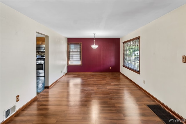 235 Wagner Ave, Cheektowaga, NY 14212 - unfurnished dining area featuring healthy amount of natural light, wood finished floors, and an accent wall