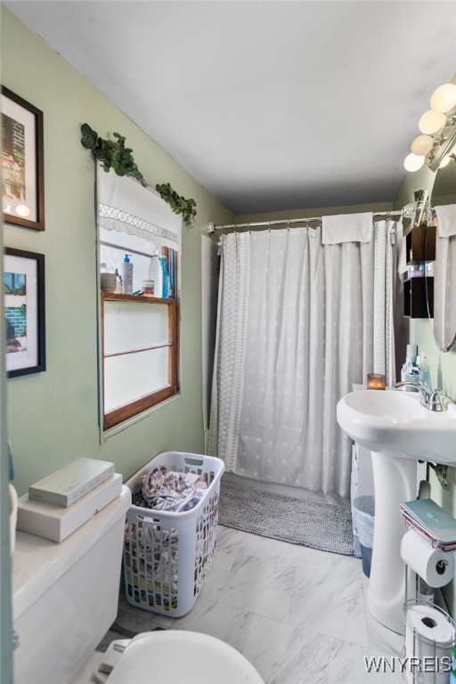 235 Wagner Ave, Cheektowaga, NY 14212 - bathroom with marble look tile flooring and a shower with curtain