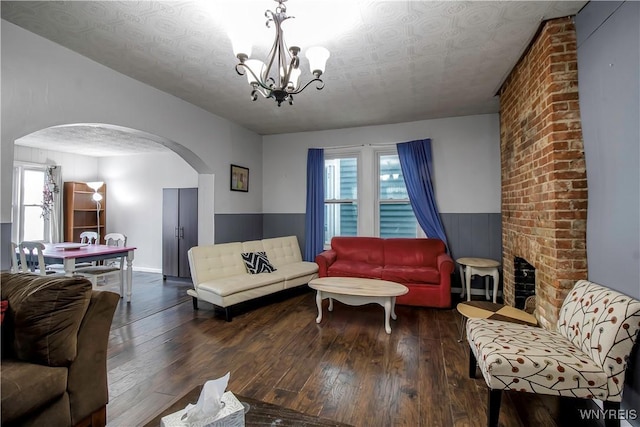 49 Massachusetts Ave, Buffalo, NY 14213 - living room with arched walkways, hardwood / wood-style floors, a chandelier, a wainscoted wall, and a textured ceiling