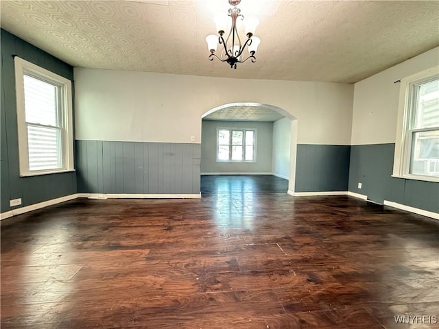 49 Massachusetts Ave, Buffalo, NY 14213 - spare room with arched walkways, wood finished floors, a chandelier, wainscoting, and wooden walls