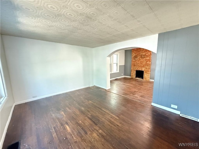 49 Massachusetts Ave, Buffalo, NY 14213 - unfurnished living room with hardwood / wood-style flooring, a fireplace, and arched walkways
