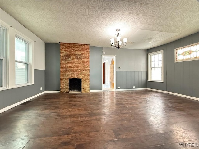 49 Massachusetts Ave, Buffalo, NY 14213 - unfurnished living room with hardwood / wood-style floors, a chandelier, an ornate ceiling, a brick fireplace, and wooden walls