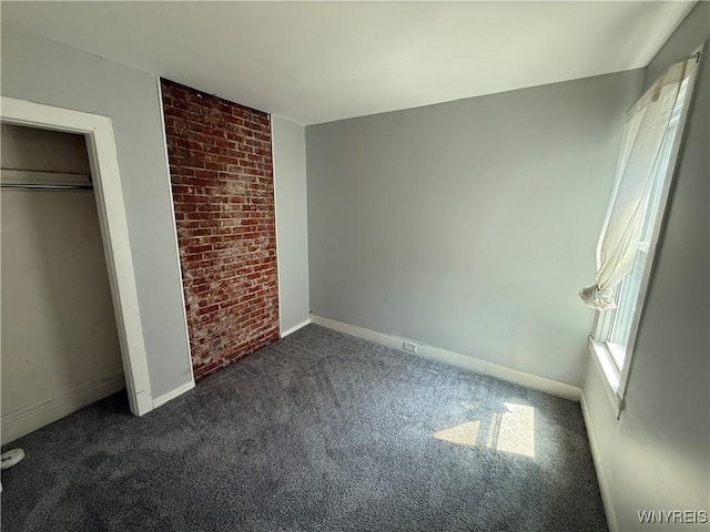 49 Massachusetts Ave, Buffalo, NY 14213 - unfurnished bedroom with dark colored carpet and brick wall