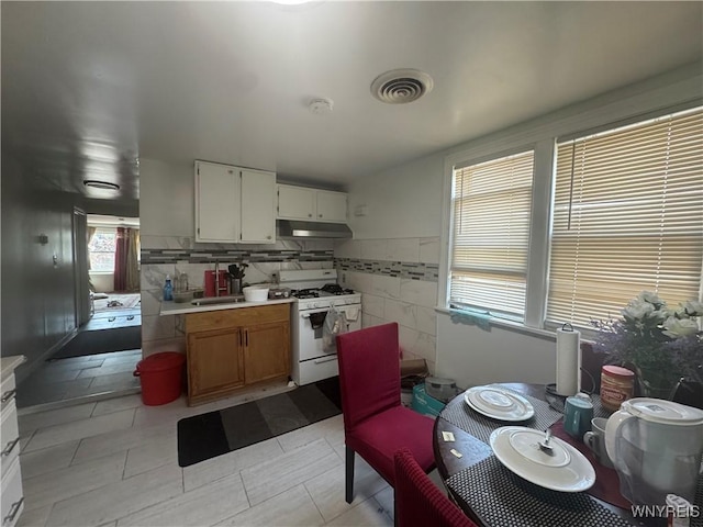 38 Langmeyer Ave, Buffalo, NY 14215 - kitchen with white range with gas cooktop, light countertops, under cabinet range hood, and white cabinets