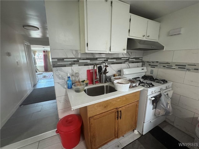 38 Langmeyer Ave, Buffalo, NY 14215 - kitchen with white gas range oven, light countertops, under cabinet range hood, light tile patterned floors, and decorative backsplash