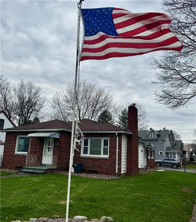 2201 Dewey Ave, Rochester, NY 14615 - view of front of house with a chimney, brick siding, and a front yard