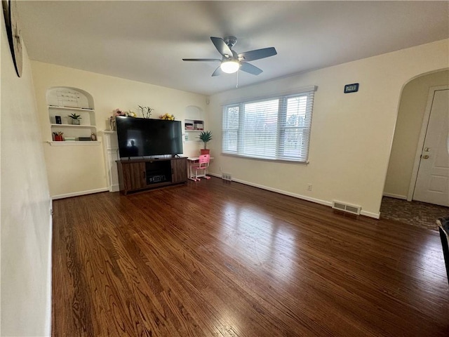 2201 Dewey Ave, Rochester, NY 14615 - unfurnished living room with wood finished floors, a ceiling fan, arched walkways, and built in features