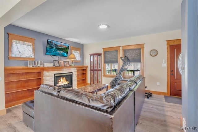 67 Amber St, Buffalo, NY 14220 - living room with healthy amount of natural light, light wood finished floors, and a stone fireplace