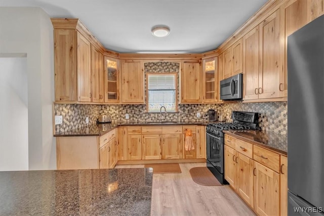 67 Amber St, Buffalo, NY 14220 - kitchen featuring range with gas stovetop, freestanding refrigerator, stainless steel microwave, glass insert cabinets, and backsplash