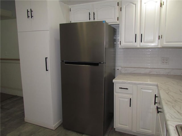 176 Selye Ter, Rochester, NY 14613 - kitchen featuring freestanding refrigerator, white cabinets, decorative backsplash, wood finished floors, and light stone countertops