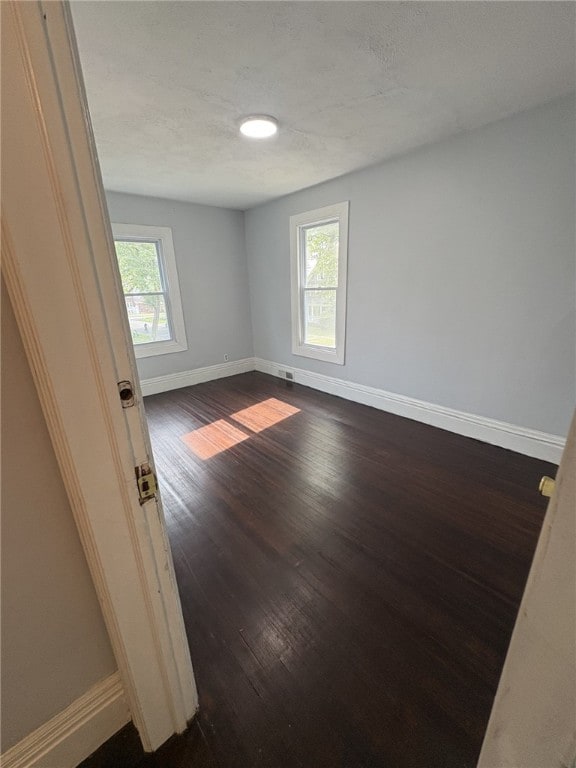 176 Selye Ter, Rochester, NY 14613 - spare room featuring baseboards and dark wood-style flooring