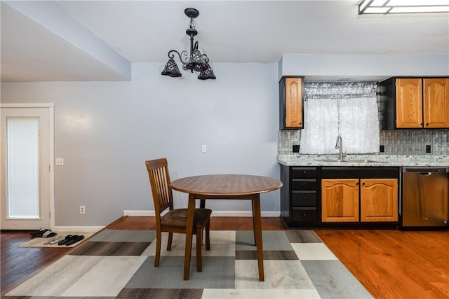 15 Dogwood Ln, Erwin, NY 14870 - kitchen featuring stainless steel dishwasher, dark wood-style floors, tasteful backsplash, decorative light fixtures, and brown cabinetry
