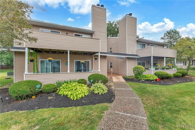 306 Sundown Unit 3C, Amherst, NY 14221 - rear view of property featuring a balcony, a chimney, and a lawn