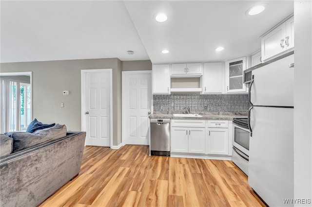 306 Sundown Unit 3C, Amherst, NY 14221 - kitchen featuring freestanding refrigerator, light wood finished floors, white cabinets, open floor plan, and backsplash