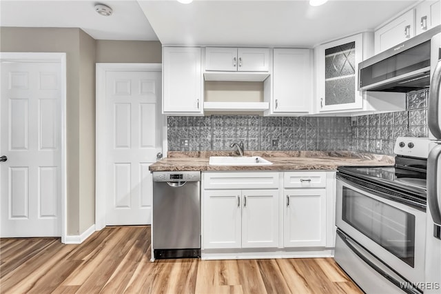 306 Sundown Unit 3C, Amherst, NY 14221 - kitchen featuring appliances with stainless steel finishes, white cabinets, light wood-style flooring, glass insert cabinets, and backsplash