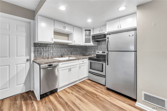 306 Sundown Unit 3C, Amherst, NY 14221 - kitchen featuring appliances with stainless steel finishes, white cabinetry, decorative backsplash, light wood-style flooring, and recessed lighting