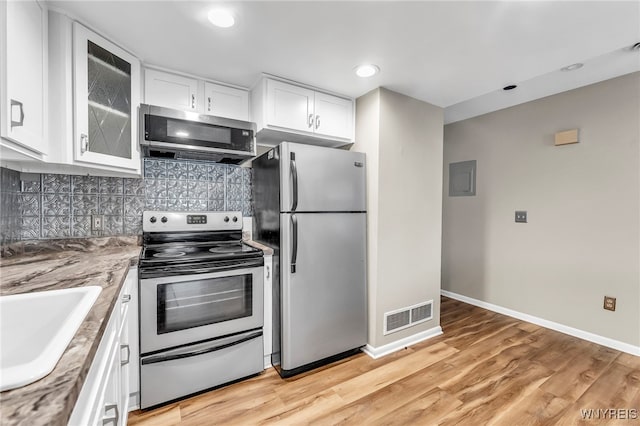 306 Sundown Unit 3C, Amherst, NY 14221 - kitchen with appliances with stainless steel finishes, white cabinets, glass insert cabinets, decorative backsplash, and light wood-type flooring