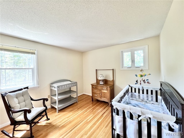 73 Eaglebrook Dr, Orchard Park, NY 14224 - bedroom with light wood finished floors, a textured ceiling, and multiple windows