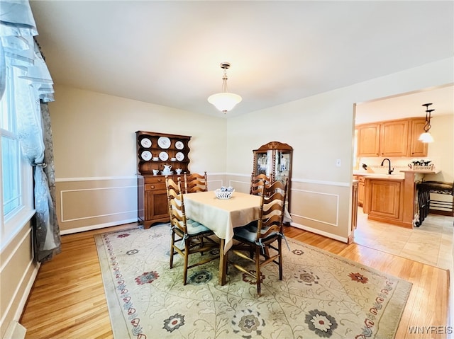 73 Eaglebrook Dr, Orchard Park, NY 14224 - dining space with light wood-style flooring and a wainscoted wall
