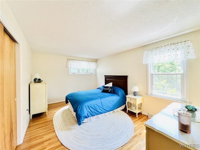 73 Eaglebrook Dr, Orchard Park, NY 14224 - bedroom with light wood-type flooring, a textured ceiling, and a closet