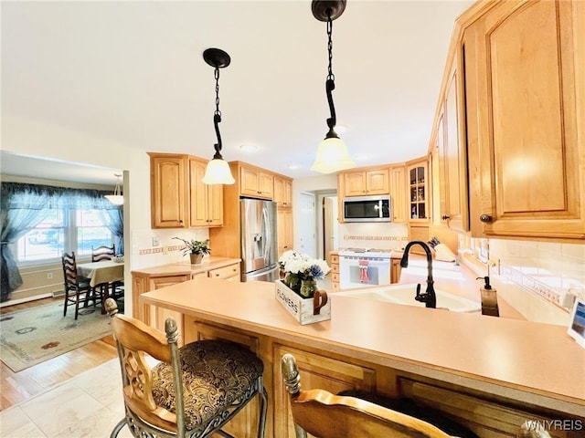 73 Eaglebrook Dr, Orchard Park, NY 14224 - kitchen featuring a peninsula, a kitchen bar, glass insert cabinets, stainless steel appliances, and pendant lighting