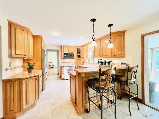 73 Eaglebrook Dr, Orchard Park, NY 14224 - kitchen featuring a peninsula, a breakfast bar area, appliances with stainless steel finishes, light countertops, and recessed lighting