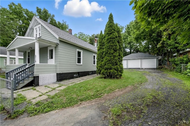 215 Vann St, Syracuse, NY 13206 - view of side of property featuring an outdoor structure, a chimney, a shingled roof, a detached garage, and covered porch