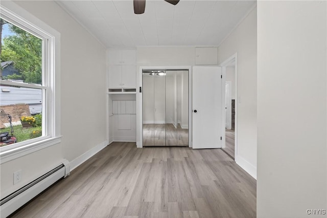 215 Vann St, Syracuse, NY 13206 - unfurnished bedroom featuring a baseboard radiator, light wood-type flooring, multiple windows, crown molding, and a closet