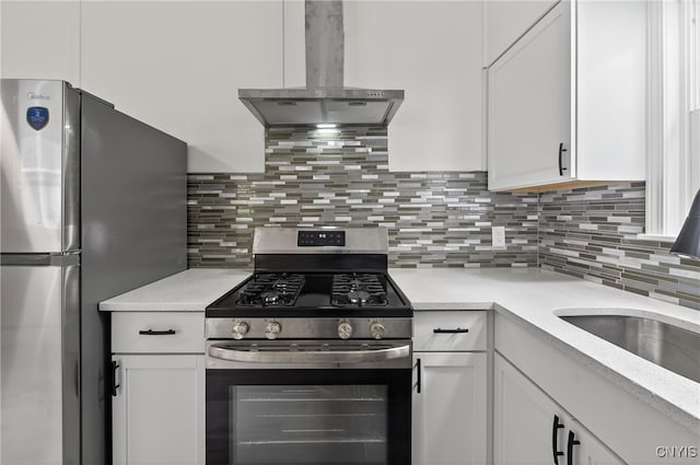 215 Vann St, Syracuse, NY 13206 - kitchen with appliances with stainless steel finishes, exhaust hood, white cabinets, and tasteful backsplash