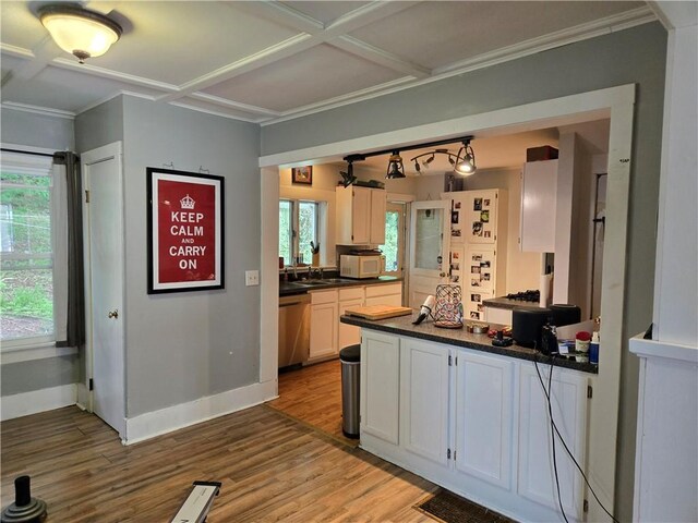 262 E 3rd St, Corning City, NY 14830 - kitchen featuring dark countertops, light wood-style flooring, ornamental molding, white cabinetry, and a peninsula