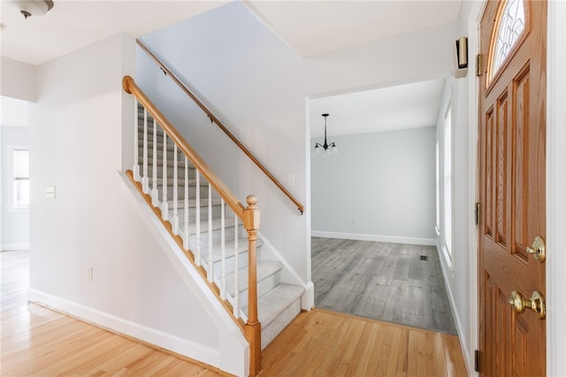 20 Parr Cir, Irondequoit, NY 14617 - entryway featuring wood finished floors, a chandelier, stairs, and healthy amount of natural light