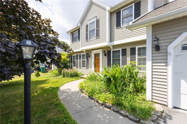 20 Parr Cir, Irondequoit, NY 14617 - property entrance featuring a yard, a garage, and roof with shingles