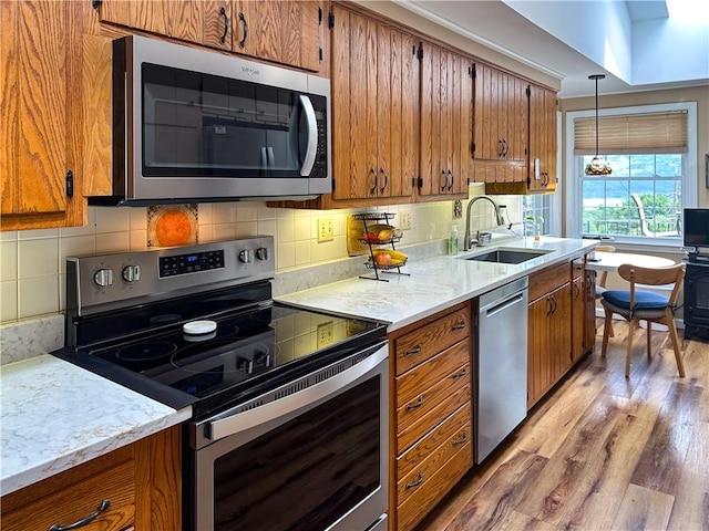 3265 Reading Rd, Reading, NY 14891 - kitchen featuring appliances with stainless steel finishes, light wood-type flooring, brown cabinetry, and backsplash