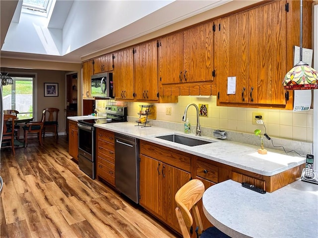 3265 Reading Rd, Reading, NY 14891 - kitchen featuring stainless steel appliances, a skylight, brown cabinetry, light countertops, and light wood finished floors