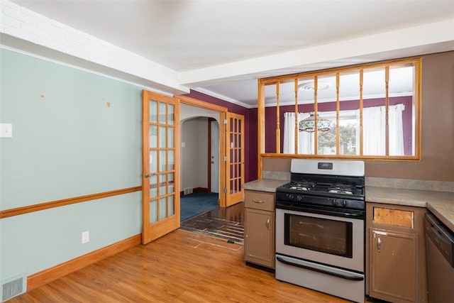 269 Michael Ave, Cheektowaga, NY 14212 - kitchen featuring appliances with stainless steel finishes, arched walkways, light wood-style floors, light countertops, and french doors