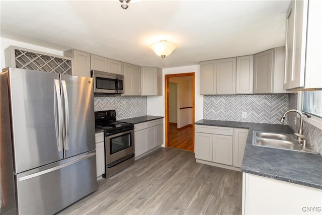 209 Pear Tree Dr, Camillus, NY 13031 - kitchen with appliances with stainless steel finishes, dark countertops, light wood finished floors, backsplash, and gray cabinets