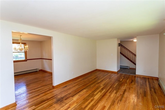 209 Pear Tree Dr, Camillus, NY 13031 - unfurnished room with wood finished floors, a chandelier, baseboard heating, and stairway